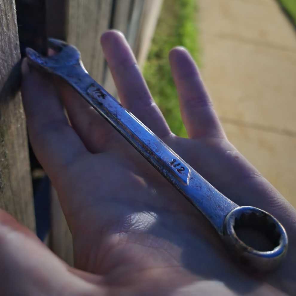 a half-inch wrench sitting on an open palm.